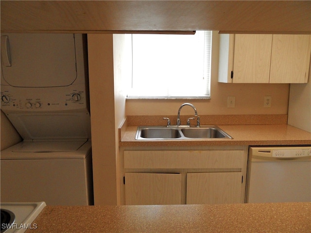 kitchen featuring white dishwasher, light brown cabinets, stacked washer / dryer, and sink