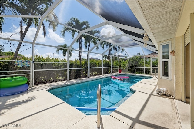 view of pool featuring glass enclosure and a patio