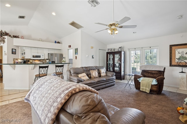 tiled living room featuring vaulted ceiling, ceiling fan, and french doors