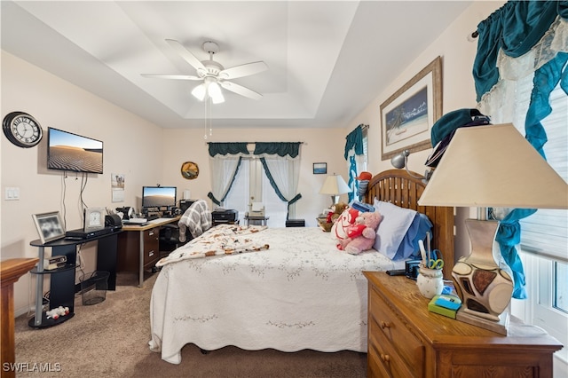 bedroom with carpet floors, ceiling fan, and a raised ceiling