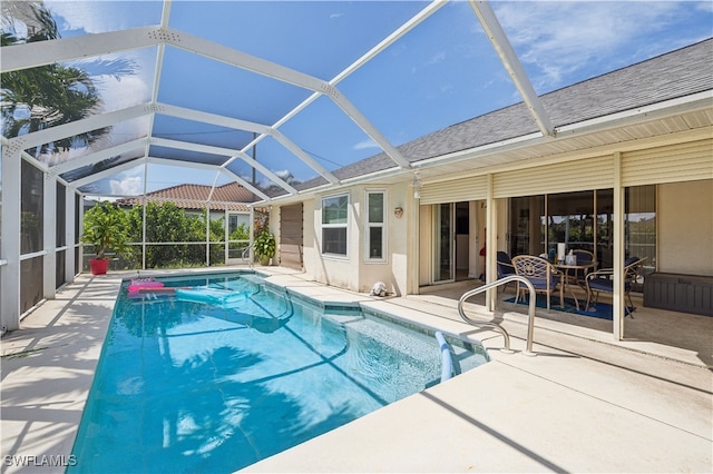 view of swimming pool with glass enclosure and a patio area