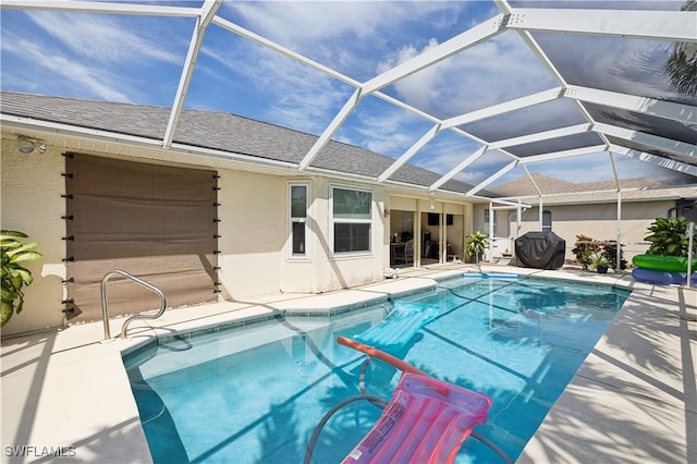 view of swimming pool with glass enclosure, grilling area, and a patio