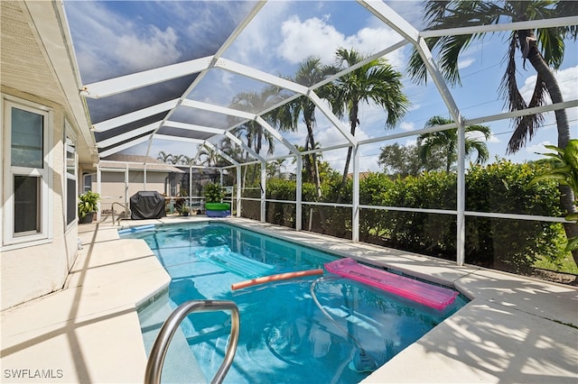 view of swimming pool featuring a lanai and a patio