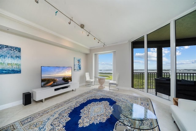 tiled living room featuring track lighting, floor to ceiling windows, and crown molding