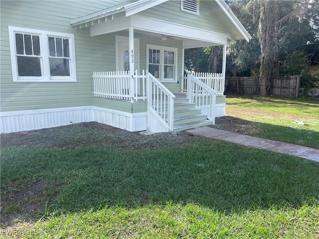 property entrance featuring fence and a yard