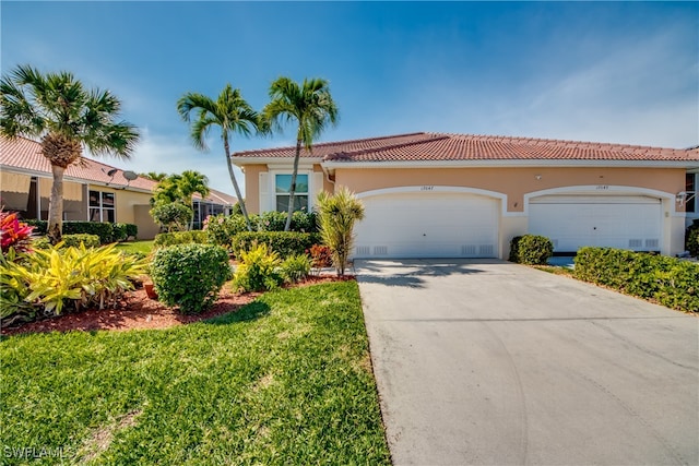 mediterranean / spanish house with a garage and a front lawn