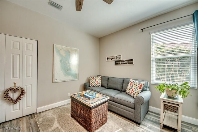 living room featuring hardwood / wood-style floors and ceiling fan