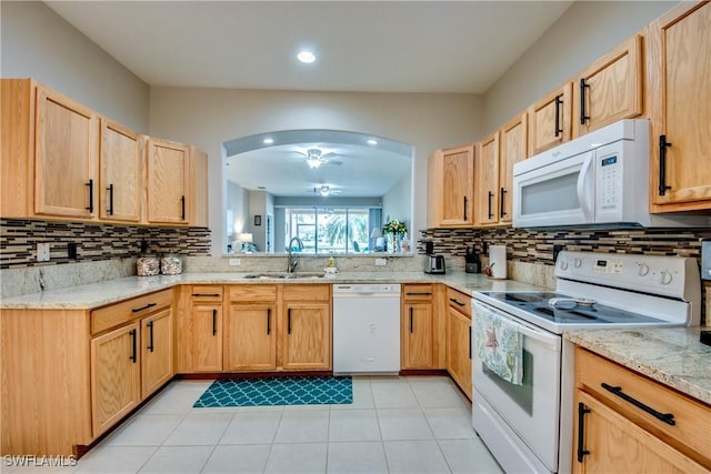 kitchen featuring light tile patterned flooring, sink, light stone counters, tasteful backsplash, and white appliances