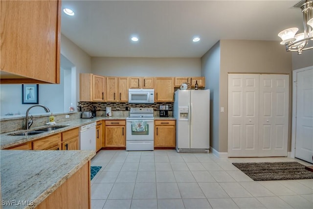 kitchen with sink, decorative light fixtures, white appliances, light stone countertops, and backsplash