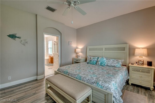 bedroom with hardwood / wood-style floors, ceiling fan, and ensuite bathroom