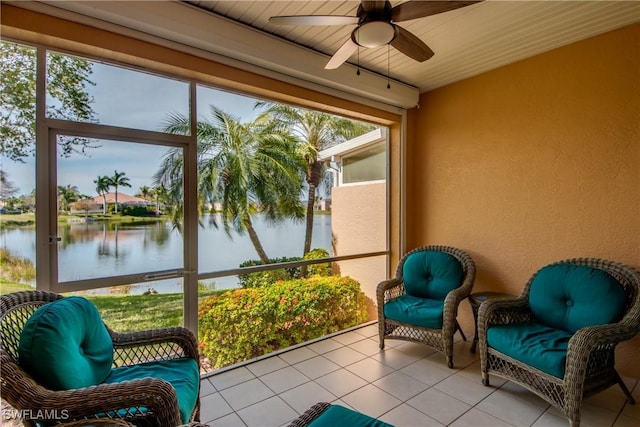 sunroom / solarium with a water view and ceiling fan