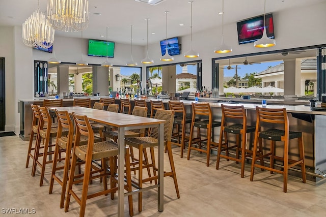 dining space featuring a towering ceiling and a notable chandelier