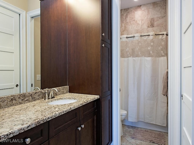 bathroom with tile patterned flooring, curtained shower, vanity, and toilet