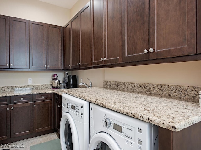 clothes washing area with washing machine and dryer and cabinets