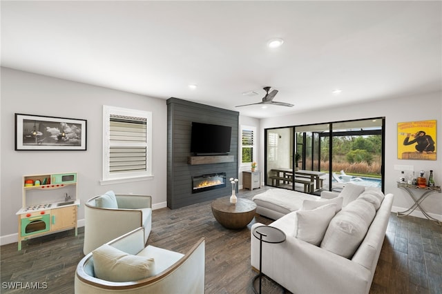 living room with dark wood-type flooring, a fireplace, and ceiling fan