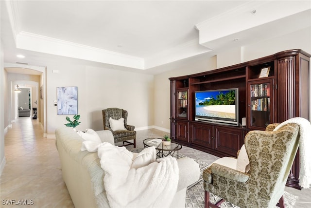 tiled living room with ornamental molding and a tray ceiling