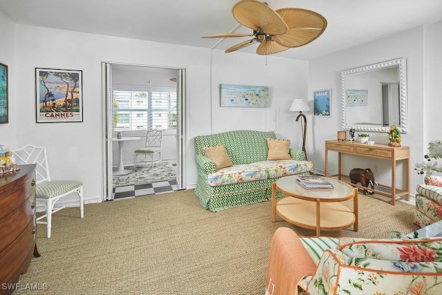 carpeted living area featuring baseboards and ceiling fan