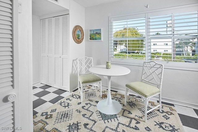 living area with tile patterned floors, plenty of natural light, and baseboards