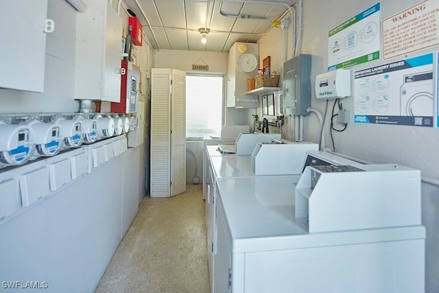 common laundry area with electric panel and washing machine and clothes dryer