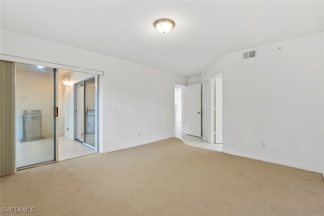 carpeted empty room with a textured ceiling