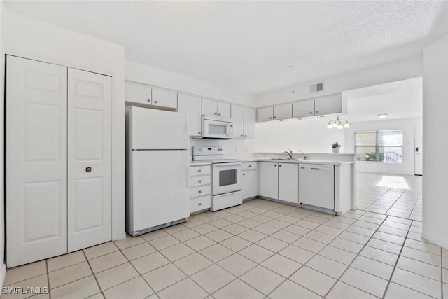 28710 Bermuda Bay Way Unit 104, Bonita Springs, FL 34134 - kitchen featuring white appliances, a sink, light countertops, a textured ceiling, and white cabinetry