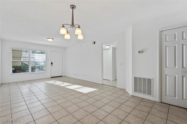 28710 Bermuda Bay Way Unit 104, Bonita Springs, FL 34134 - unfurnished room featuring a chandelier, light tile patterned floors, and baseboards