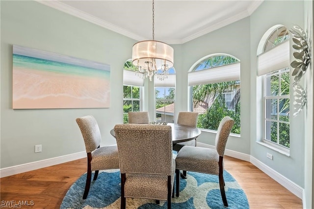 dining area featuring crown molding, a healthy amount of sunlight, wood finished floors, and a chandelier