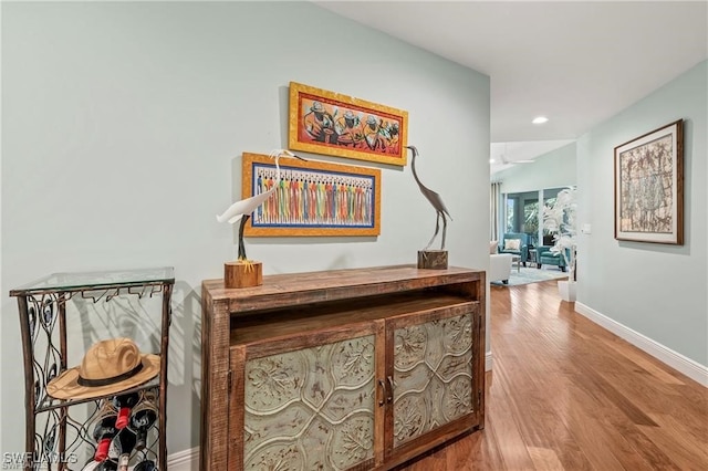 hallway with recessed lighting, baseboards, and wood finished floors