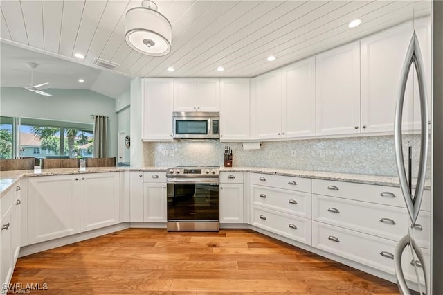 kitchen featuring light wood-style flooring, backsplash, white cabinetry, appliances with stainless steel finishes, and lofted ceiling