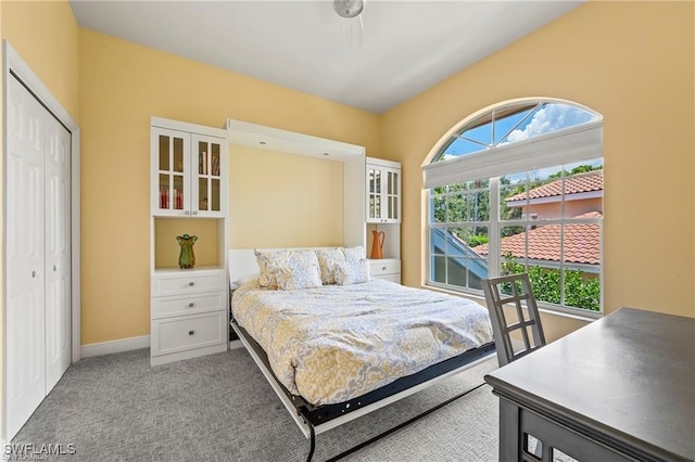 bedroom with light colored carpet, a closet, and baseboards