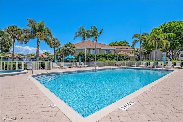 community pool featuring a patio area and fence