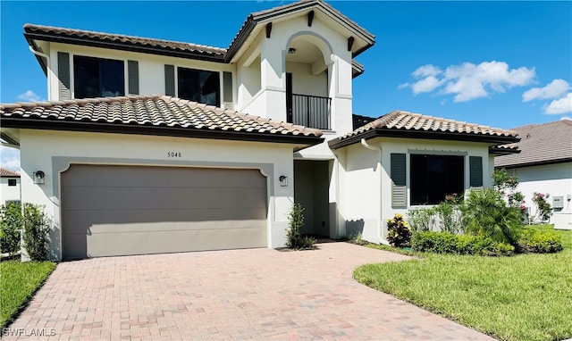 mediterranean / spanish-style home with a front yard and a garage