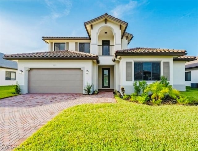 mediterranean / spanish-style home featuring a balcony, a garage, and a front lawn