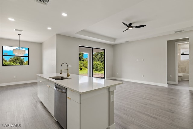 kitchen featuring ceiling fan, sink, stainless steel dishwasher, an island with sink, and decorative light fixtures