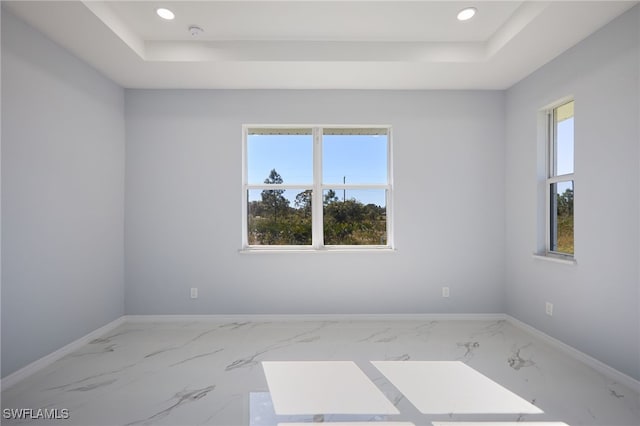 spare room with a tray ceiling