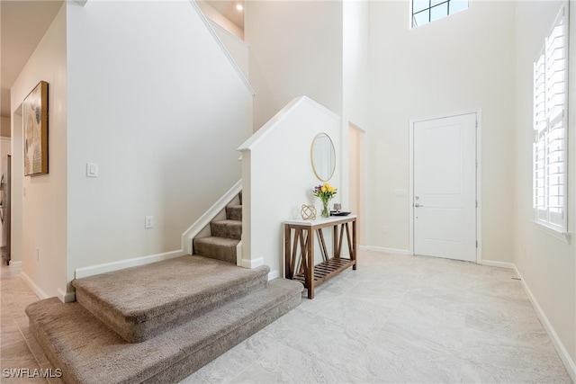 entryway with a high ceiling and a wealth of natural light