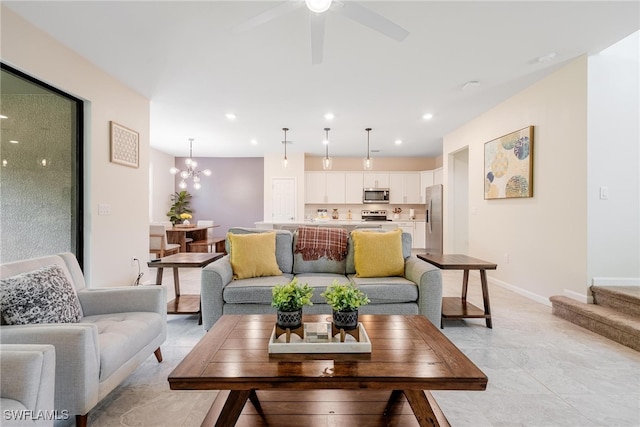 tiled living room featuring ceiling fan with notable chandelier