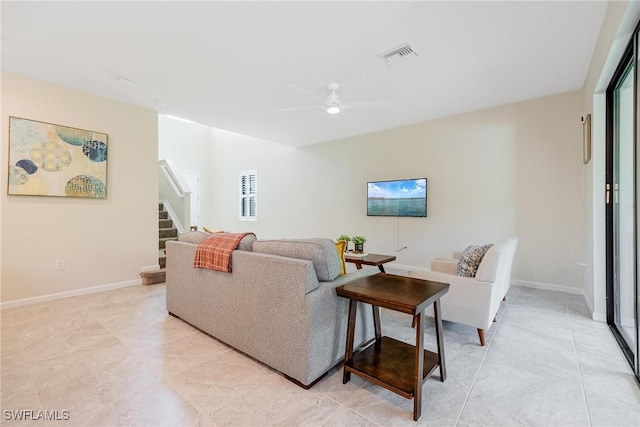 living room featuring visible vents, stairway, a ceiling fan, and baseboards