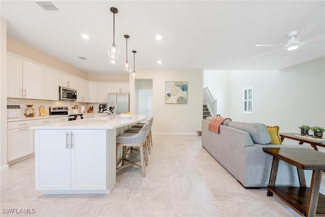 kitchen with visible vents, light countertops, decorative backsplash, stainless steel appliances, and white cabinetry