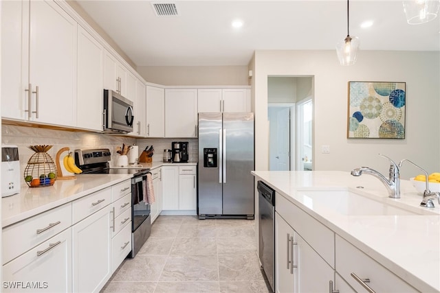 kitchen with white cabinets, sink, decorative light fixtures, stainless steel appliances, and decorative backsplash