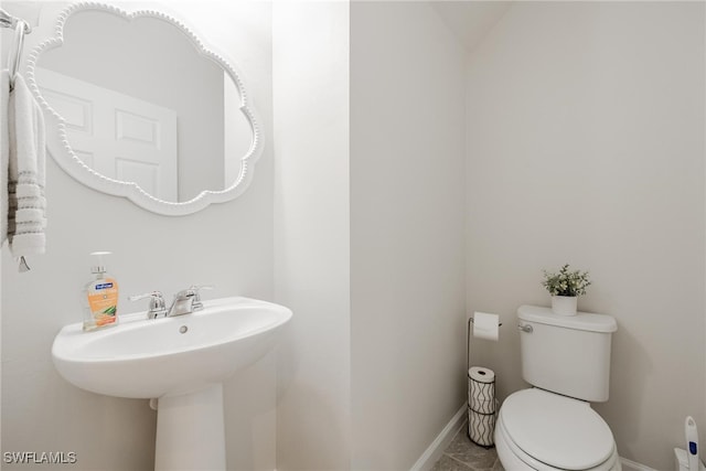 bathroom featuring toilet, sink, and tile patterned floors