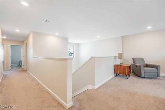 corridor featuring an upstairs landing, visible vents, carpet floors, and baseboards