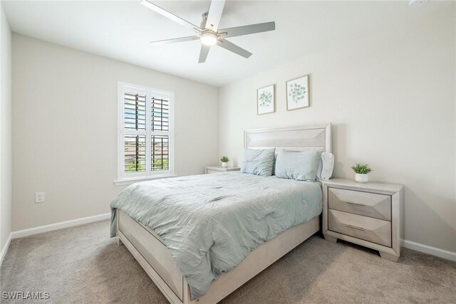 bedroom with light carpet, ceiling fan, and baseboards