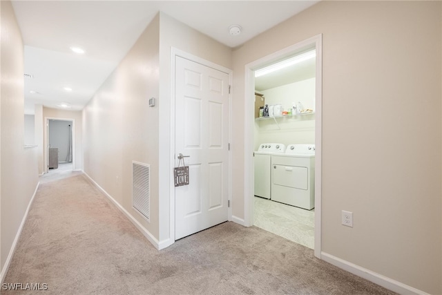 corridor featuring light colored carpet and independent washer and dryer