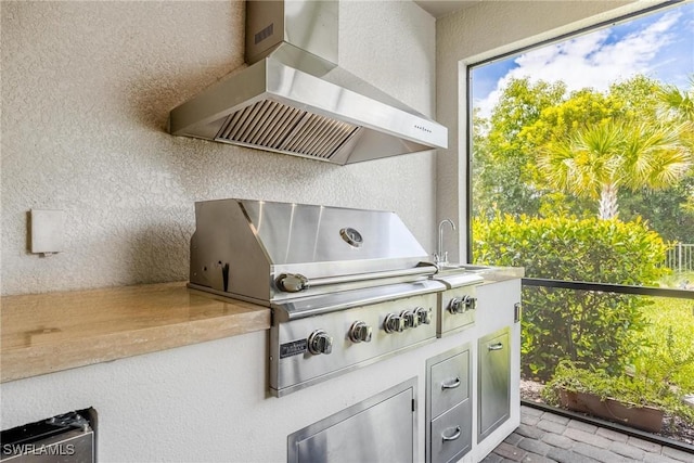 exterior space with wall chimney exhaust hood and stucco siding