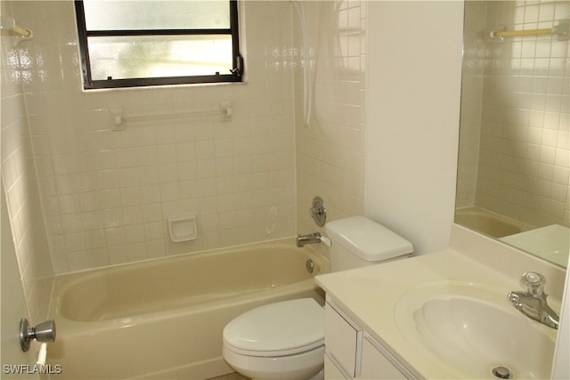 full bathroom featuring vanity, tiled shower / bath combo, and toilet