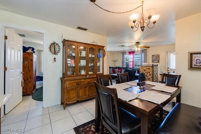 dining space featuring ceiling fan with notable chandelier and light tile patterned flooring