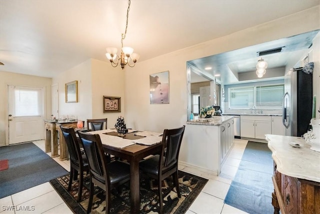 tiled dining area featuring sink and a notable chandelier