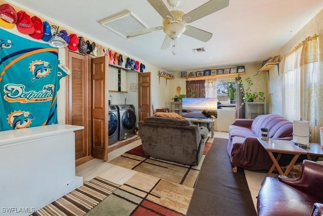 living room with washing machine and clothes dryer, ceiling fan, and light tile patterned floors