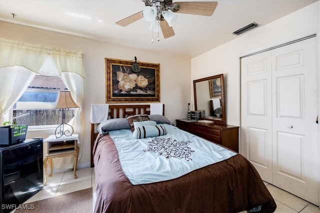 bedroom featuring ceiling fan, a closet, and light tile patterned flooring